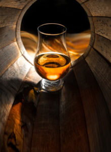a glass of whisky in a barrel