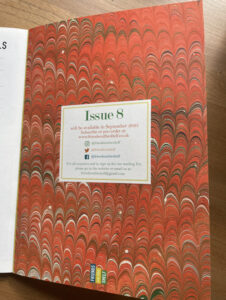 Marbled end papers in a magazine with an orange swirling pattern