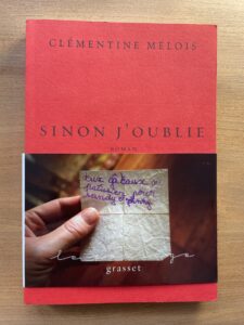 A red book with a picture of a hand holding a shopping list written in French